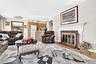 Another view of the very large, bright and inviting Living Room, featuring hardwood flooring, lots of windows, woodburing Fireplace.