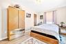 Another view of the large and bright Primary Bedroom with hardwood flooring and large windows.
