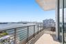 Covered balcony featuring natural stone flooring and horizontal metal railings