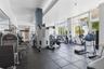 Fitness center featuring large-format floor tiling, recessed lighting, floor-to-ceiling windows, and mirrored wall surfaces