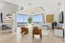 Open-concept living space featuring a sculptural spiral staircase with wood-tread steps, polished stone flooring, recessed ceiling lighting, and floor