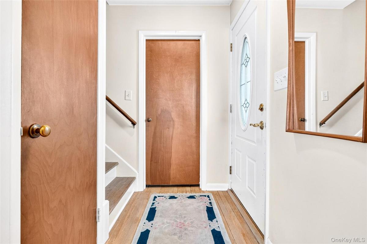 Spacious and inviting entry hall, featuring hardwood flooring and coat closet.