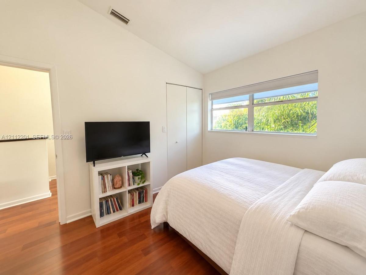 Vaulted ceilings, wood-finish flooring, horizontal sliding window, and built-in closet with dual doors