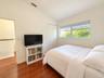Vaulted ceilings, wood-finish flooring, horizontal sliding window, and built-in closet with dual doors