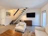 Open-tread staircase with dark wood-finish steps and white metal railings, large-format tile flooring, and full-glass panel door