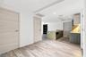 Kitchen featuring a stone-topped island, wood-finish flooring, built-in cabinetry with integrated under-cabinet lighting, and flat-panel interior door