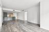 Open-concept interior featuring wood-finish flooring, two-tone cabinetry, a peninsula counter, and recessed lighting