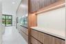 Full-height wood-finish cabinetry featuring integrated appliances, minimalist hardware, quartz countertops, and built-in under-cabinet LED lighting