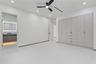 Built-in floor-to-ceiling cabinetry, recessed lighting, matte black ceiling fan, and large-format tile flooring