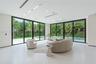 Large-format sliding glass doors, polished porcelain flooring, recessed linear lighting, built-in ceiling speakers, and perimeter patio access