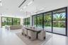 Open-concept interior featuring large-format tile flooring, recessed linear lighting, and floor-to-ceiling sliding glass doors
