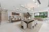 Open-concept interior featuring large-format flooring, a kitchen island with stone-surface counters, integrated LED accent lighting, floating staircas
