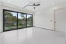 Floor-to-ceiling sliding glass doors with black frames, large-format tile flooring, recessed lighting, matte black ceiling fan, and solid-core interio