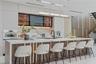 Contemporary kitchen featuring a stone-surface waterfall island with integrated vertical lighting, flat-panel cabinetry, a stone backsplash, built-in 