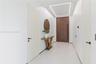 Entryway featuring a large-format wood-finish front door with a vertical pull handle, recessed linear ceiling lighting, minimalist flat-panel interior