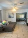 Ceramic tile flooring, white ceiling fan with integrated light fixture, and wide entryway featuring double doors
