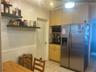 Kitchen area featuring light-finish cabinetry, stainless steel side-by-side refrigerator, floating shelving, white wainscoting, and ceramic tile floor
