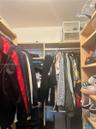 Custom walk-in closet featuring light-finish wood shelving, integrated hanging rods, and built-in vertical storage compartments