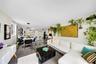 Open concept living space featuring polished tile flooring, recessed lighting, and a modern kitchen island with breakfast bar seating