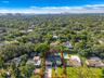 Aerial view of the single-story home with attached garage, driveway, and backyard pool
