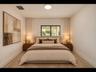 Sleek black-framed window brings in natural light, complemented by recessed lighting and soft neutral tones