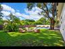 Enjoy evenings by the stone fire pit beside the pool, surrounded by mature trees and privacy fencing