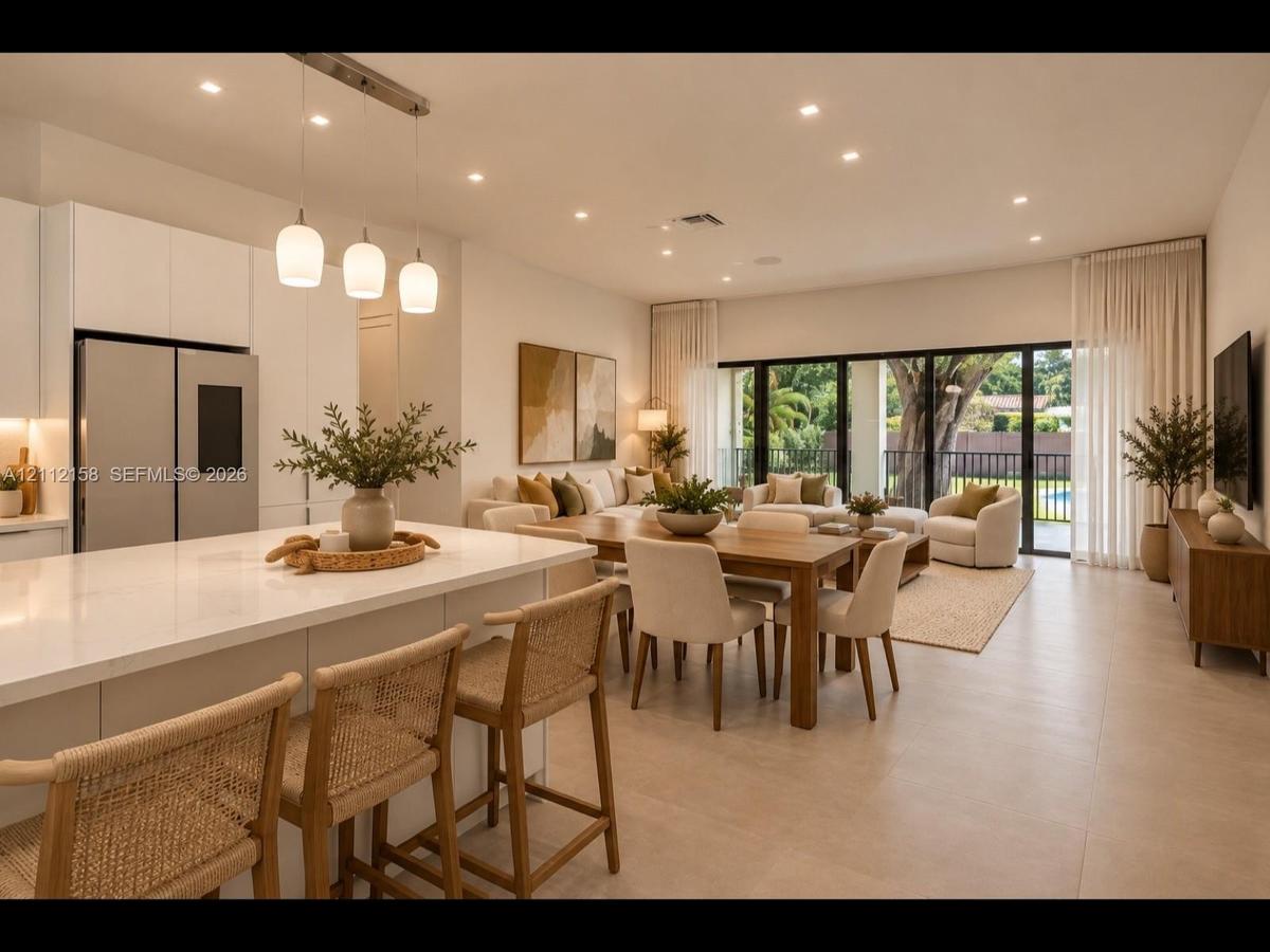 Light-filled open floor plan with quartz countertops, statement triple-pendant lighting, and sliding glass doors