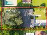Aerial view showcasing the private pool, paver walkway, and lush, mature landscaping surrounding the home