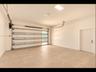 Finished garage with clean tile flooring, bright white walls, frosted-glass garage door for natural light, and direct interior access