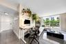 Large-format tile flooring, recessed ceiling lighting, and sliding glass door with access to a railed balcony