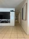 Large-format square tile flooring, neutral wall finishes, and custom white built-in cabinetry featuring integrated storage