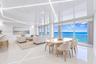 High-gloss reflective ceiling with integrated linear LED lighting, polished stone flooring, and expansive floor-to-ceiling glass sliding doors opening