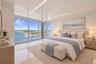 Floor-to-ceiling glass sliding doors, high-gloss ceiling finish, recessed linear lighting, polished tile flooring, and a private balcony with railing