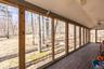 Unfurnished sunroom featuring a ceiling fan, vaulted ceiling, and a wooden deck