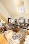 Living room with light wood finished floors and vaulted ceiling