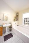 Full bathroom with a garden tub, vaulted ceiling, and light tile patterned floors