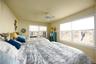 Bedroom with ceiling fan and multiple windows