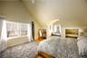 Bedroom featuring multiple windows, ceiling fan, lofted ceiling, and light wood-style floors