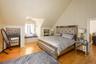 Bedroom with light wood-type flooring and vaulted ceiling