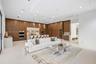 Full-height wood cabinetry, recessed ceiling lighting, stone-topped island with integrated seating, professional-grade stainless steel double wall ove