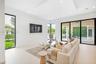 Open-concept living space featuring high ceilings with integrated recessed lighting, large-format tile flooring, a recessed ceiling detail, and floor-