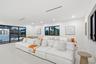 Open-concept living space featuring high ceilings, recessed lighting, expansive sliding glass doors, and dark-framed windows