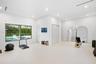 Spacious room featuring high ceilings, recessed lighting, smooth-finish flooring, and a wide window with dark metal framing