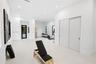 Spacious room featuring high ceilings, recessed lighting, matte-finish light-toned flooring, sliding double closet doors, and black-framed windows