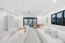Open-concept interior featuring recessed ceiling lighting, smooth-finish flooring, multi-panel sliding glass doors with dark frames, and large horizon