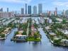 Waterfront property situated on a corner lot featuring a private dock, expansive lawn, and multi-story architectural design