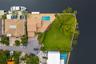 Waterfront property featuring a wraparound seawall, swimming pool with paved decking, extensive lawn, and mature perimeter landscaping
