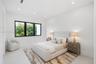 Neutral-toned room featuring large windows with black frames and recessed lighting