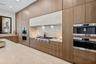 Kitchen featuring floor-to-ceiling wood cabinetry, a stone-surfaced kitchen island, integrated stainless steel appliances, a professional-style gas ra