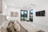 Large-format tile flooring, recessed ceiling lighting, sliding glass door with black frame, tall fixed-pane window, and white interior wall finish